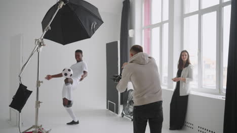 photographer-is-taking-photos-of-professional-football-player-in-studio-for-social-media